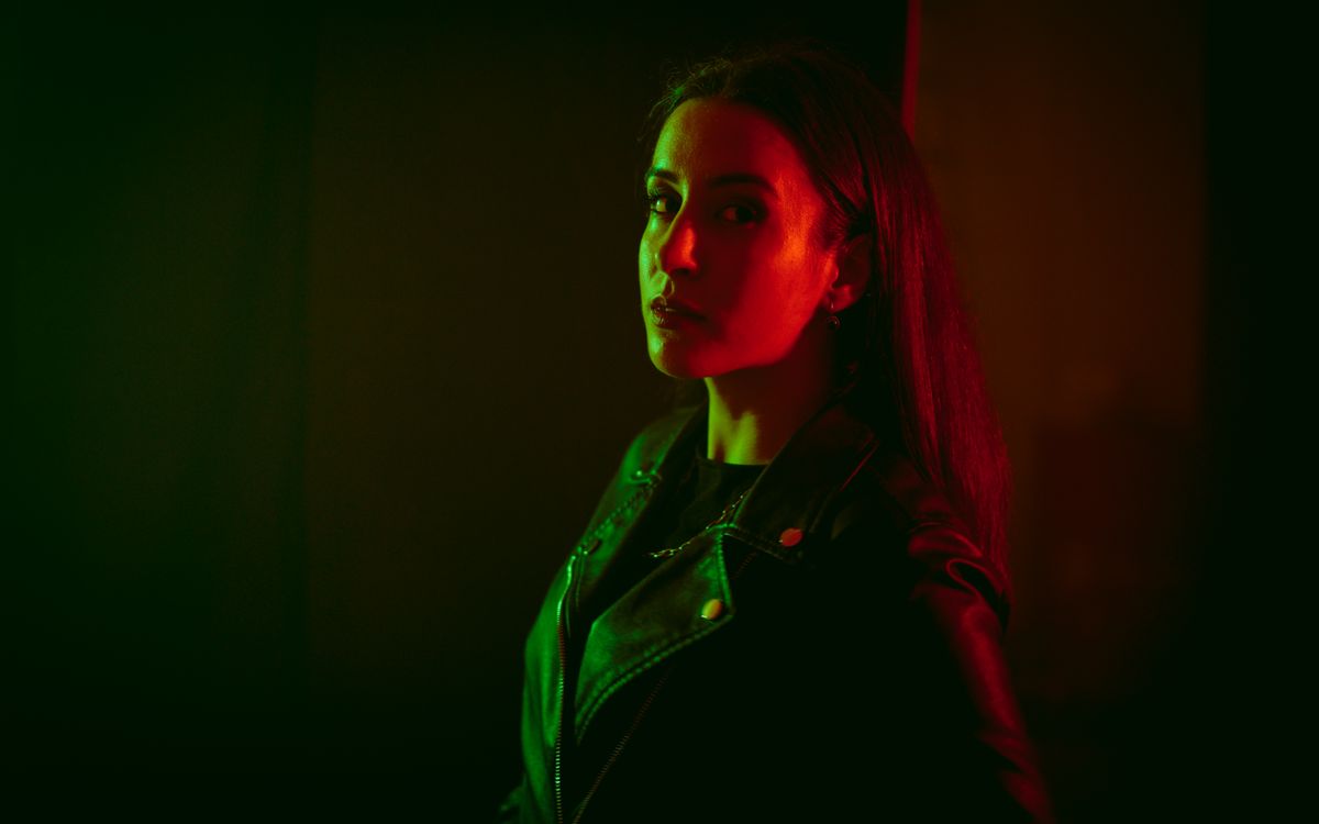Nastrojowy portret studyjny kobiety w czarnej skórzanej kurtce