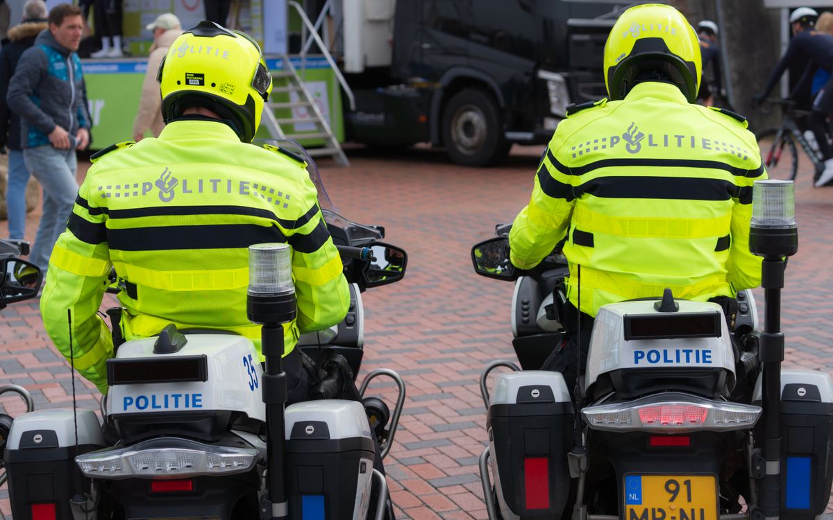 Dwóch policjantów w jasnych mundurach patroluje wydarzenie publiczne na motocyklach