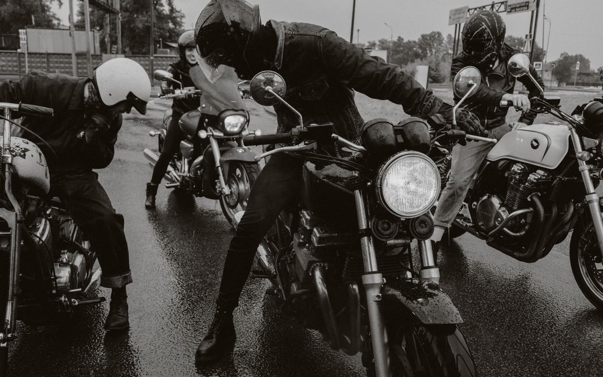 Grupa motocyklistów jedzie mokrą drogą